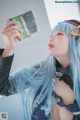 A woman with blue hair holding up a book.