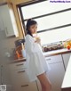 A woman standing in a kitchen holding a glass of orange juice.