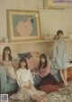 A group of young women sitting on a couch in a living room.